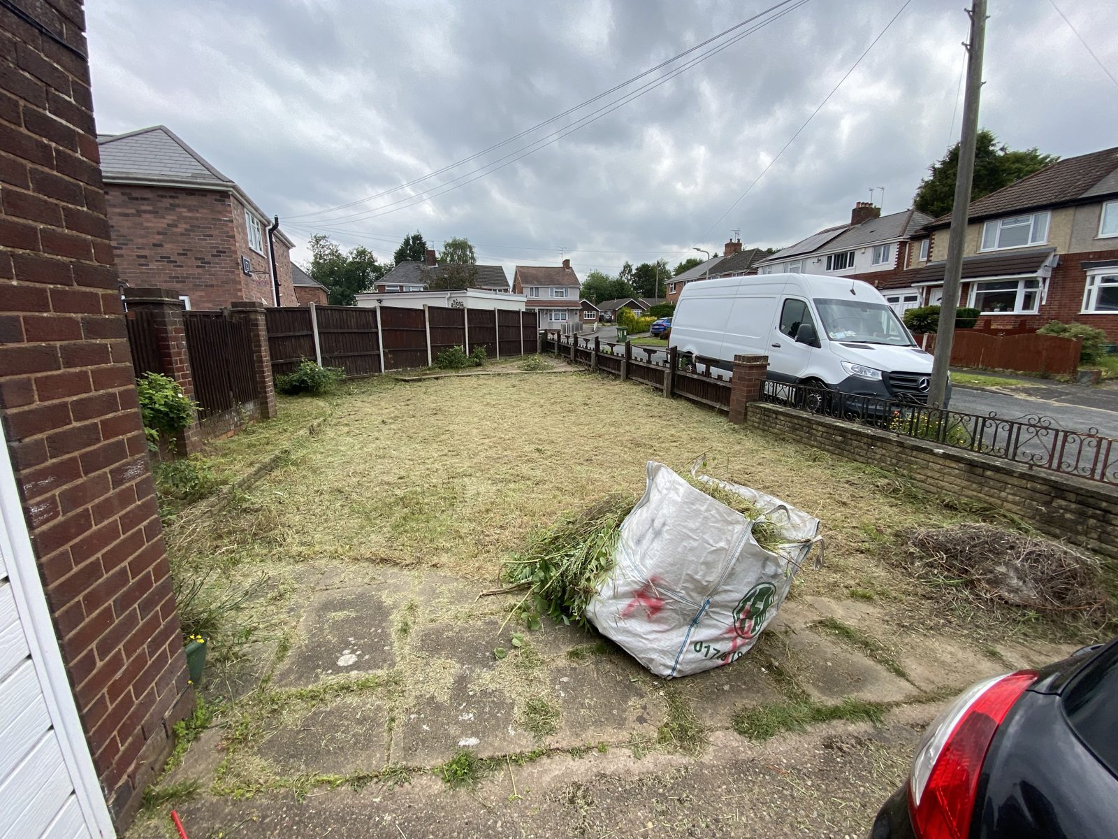 Mown lawn and cleared paving with the green waste bagged up