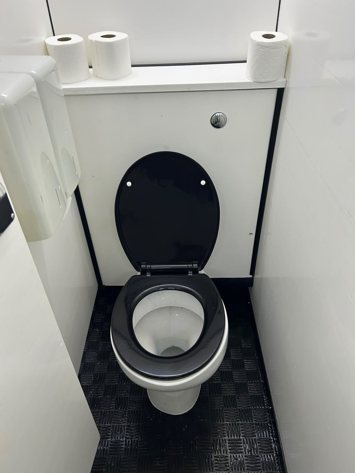 Clean toilet cubicle with fresh toilet rolls at a festival
